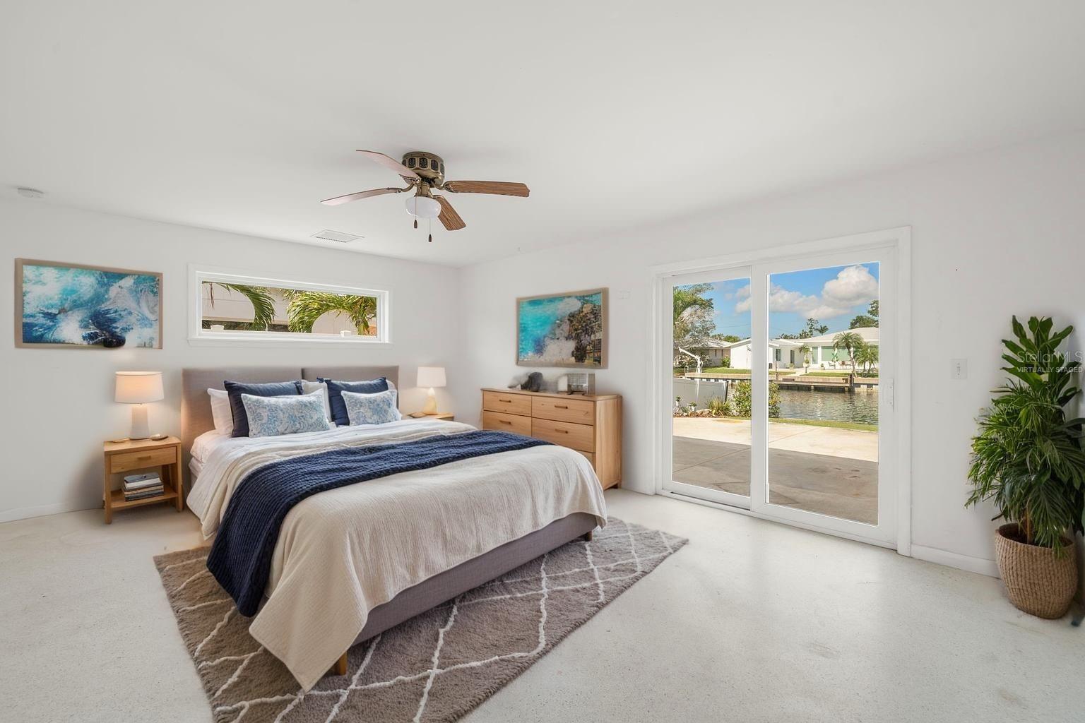 Primary Suite ... with Impact sliding glass doors providing waterfront views and a patio for your morning coffee or ease of access to your future pool... (Virtually Staged)
