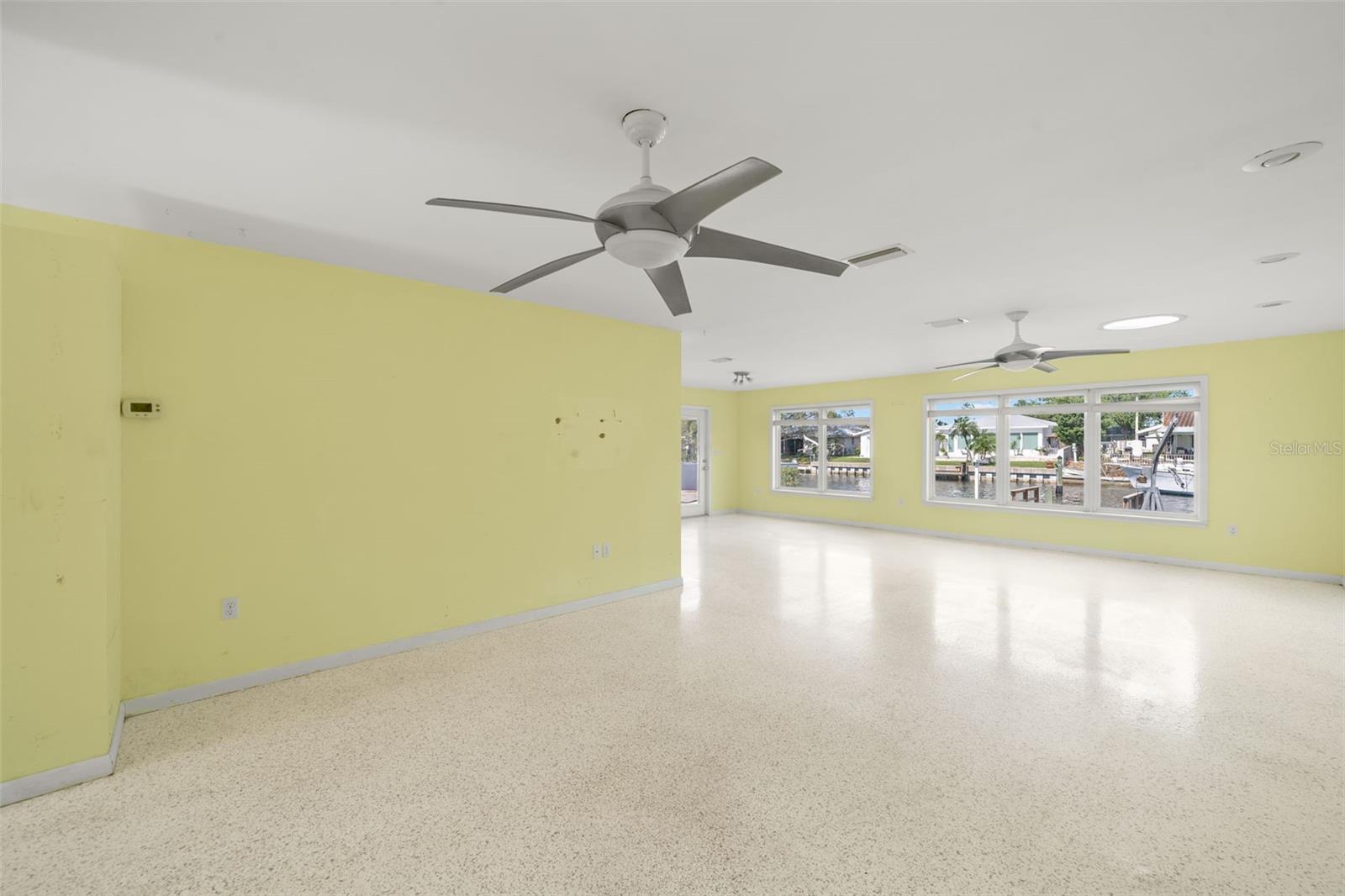 The expansive living boasting with natural light from skylights (2) and picture windows (Impact glass), with views of the water and nightly sunsets.