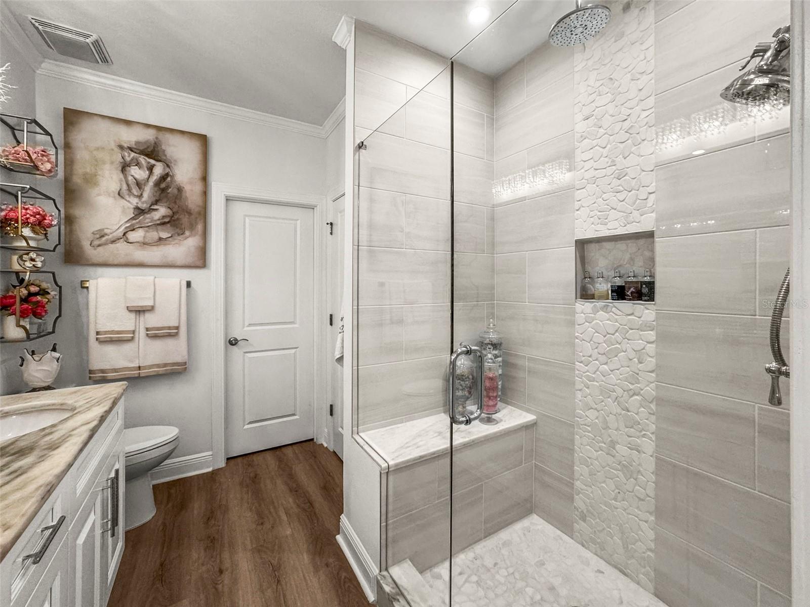 Large multi-head primary shower with bench seat