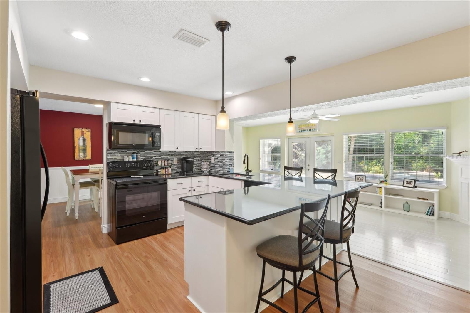 Updated kitchen, open floor plan overlooking the family room and pool