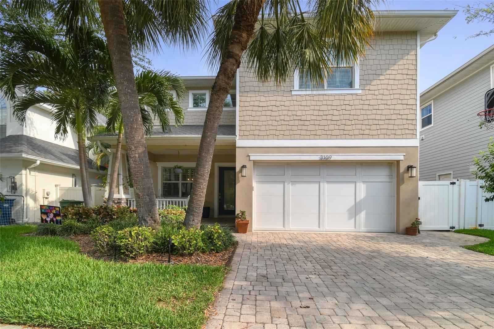 Front elevation, two car garage, welcoming front porch, mature landscape with lightning
