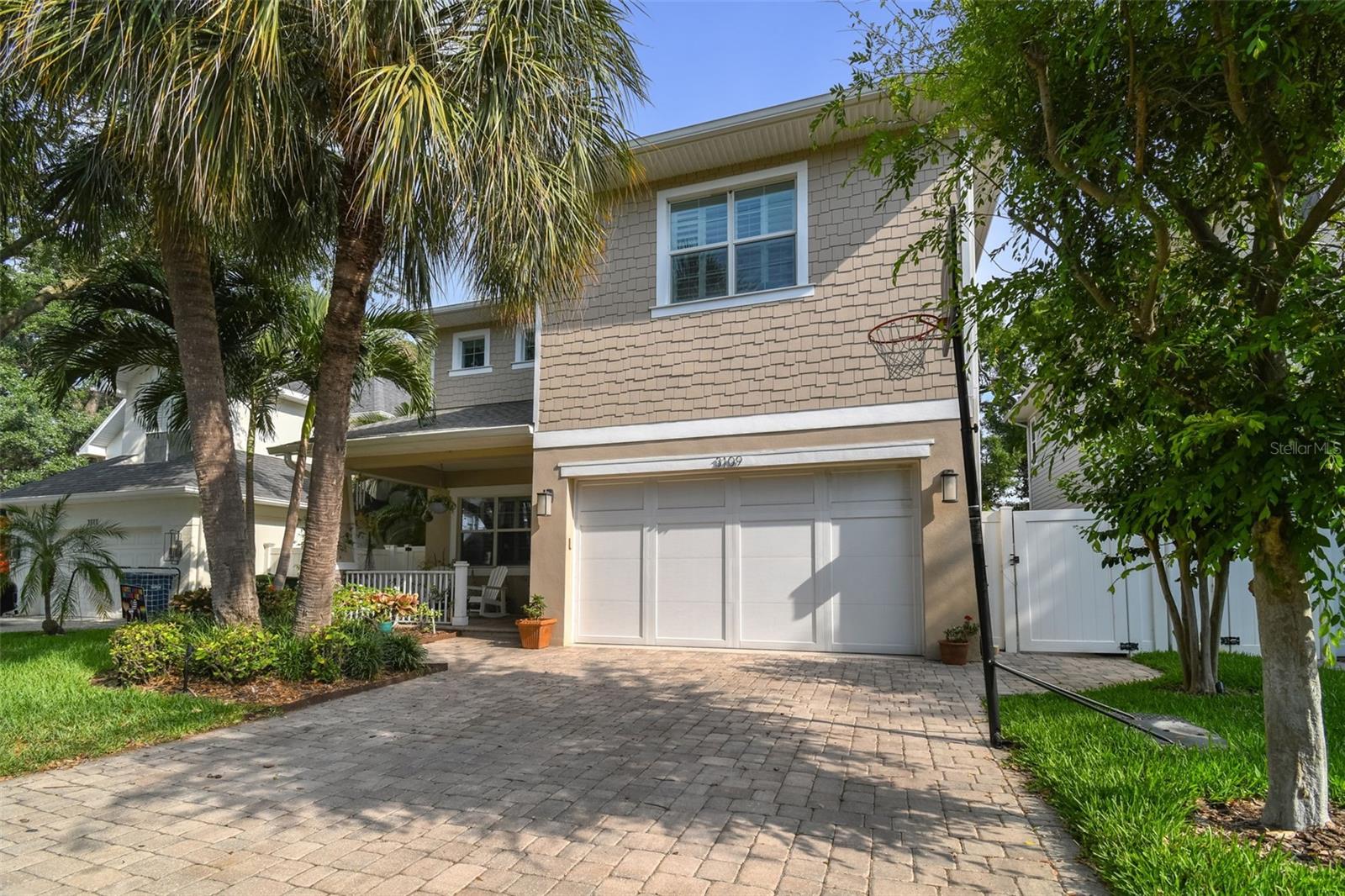 Front elevation, two car garage, welcoming front porch, mature landscape with lightning