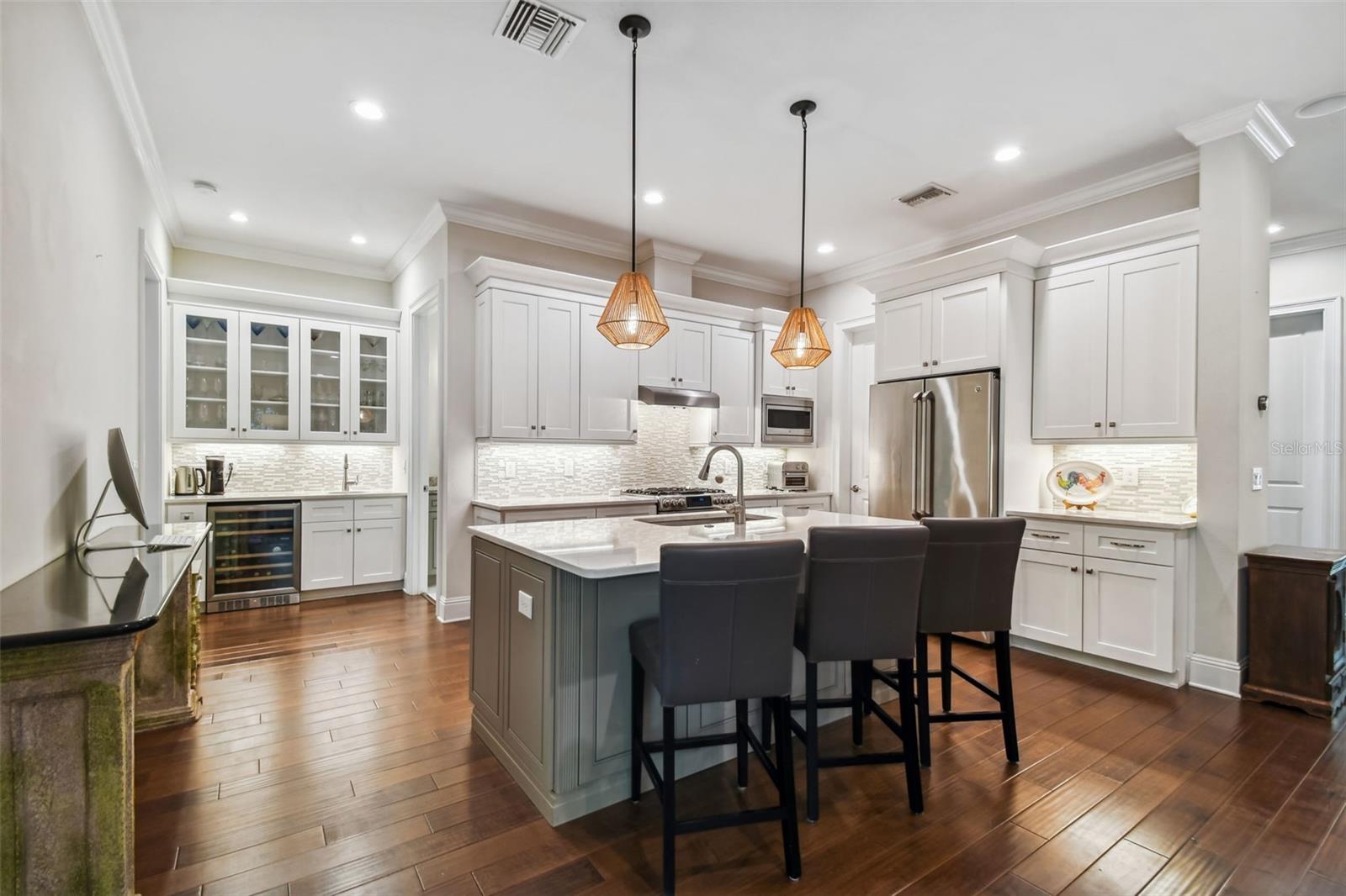 Kitchen with gas cooktop, wet bar, beverage fridge, and seating