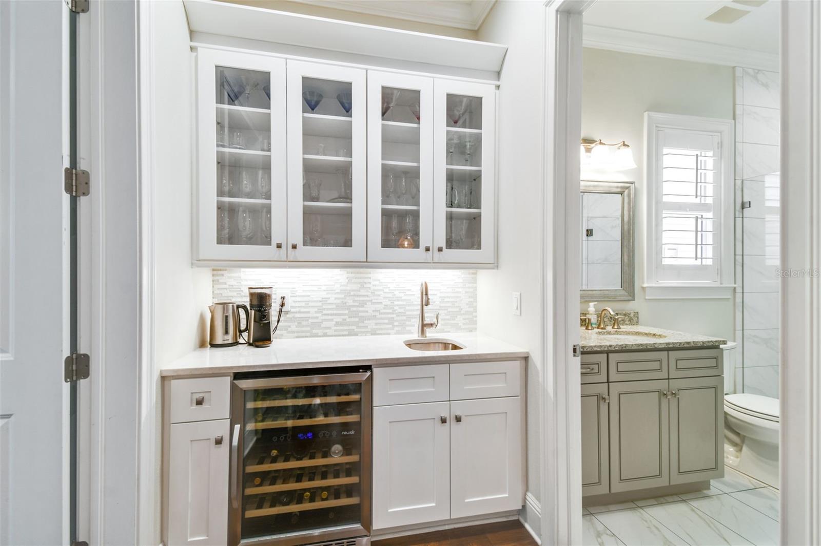 Wet bar, beverage fridge, and first floor full bath off of a guest bedroom