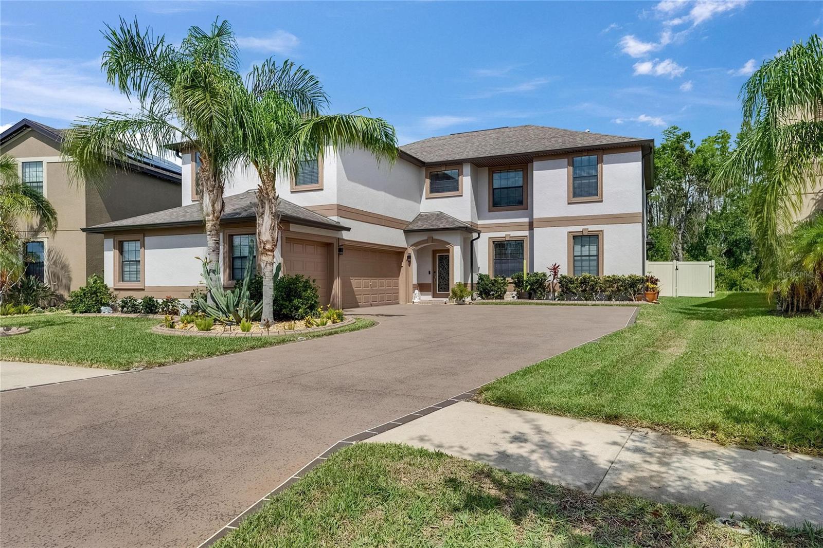 Amazing curb appeal with a side-load garage, beautifully etched and detailed driveway, and meticulously maintained landscaping.