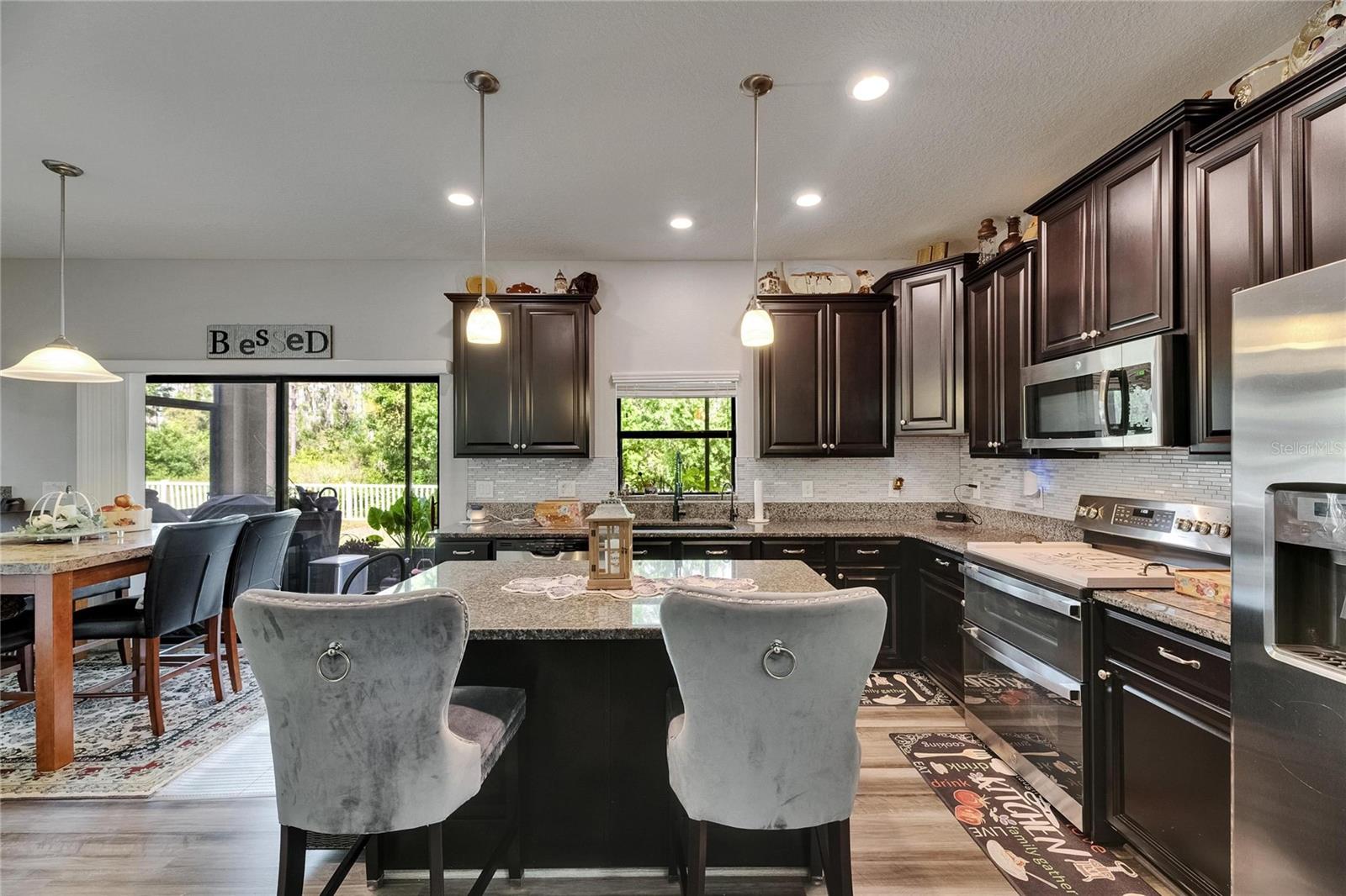 A wonderful center island offers additional seating and extra workspace, complemented by a full suite of stainless steel appliances.