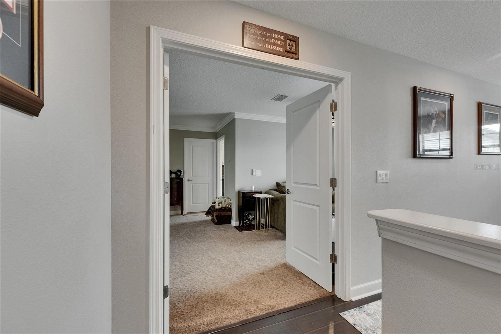 The primary bedroom showcases elegant French doors leading to a private en suite sitting room, his-and-her walk-in closets, and a tastefully designed master bath.