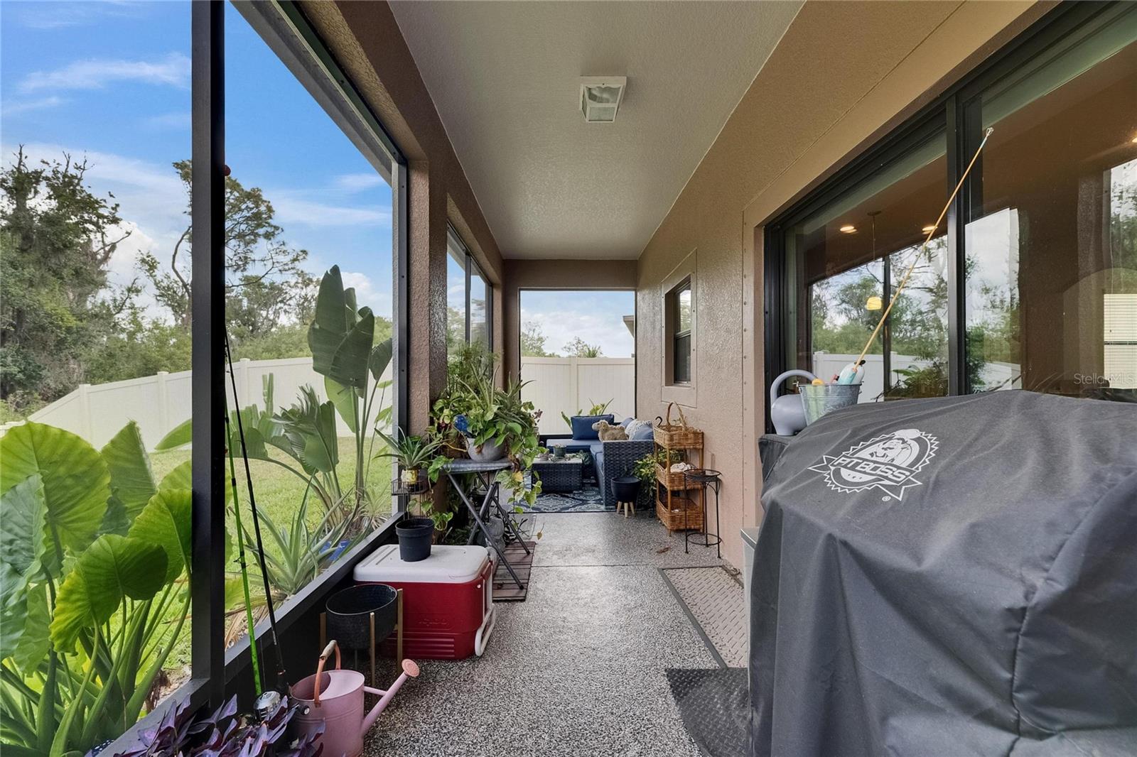 Enjoy peace and quiet in the screened-in lanai, featuring easy-to-clean epoxy flooring and enhanced privacy with a fully fenced backyard.