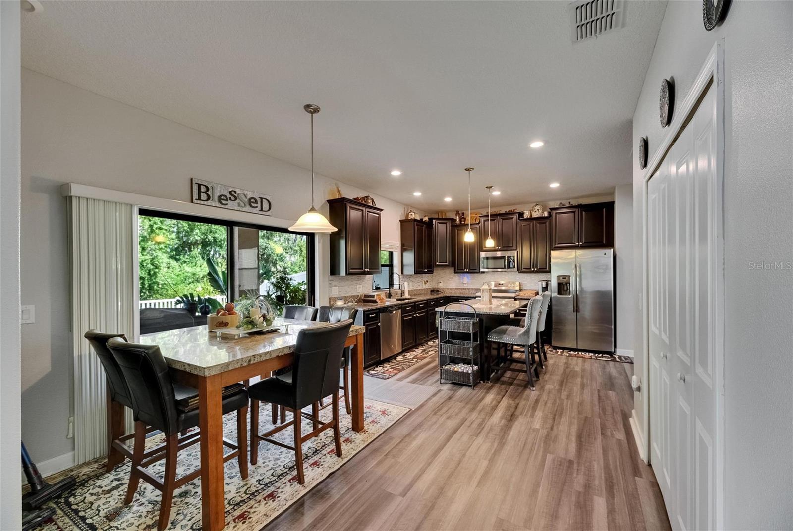 The spacious eat-in kitchen features sliding glass doors that open to the lanai, offering serene views of the lush conservation area.