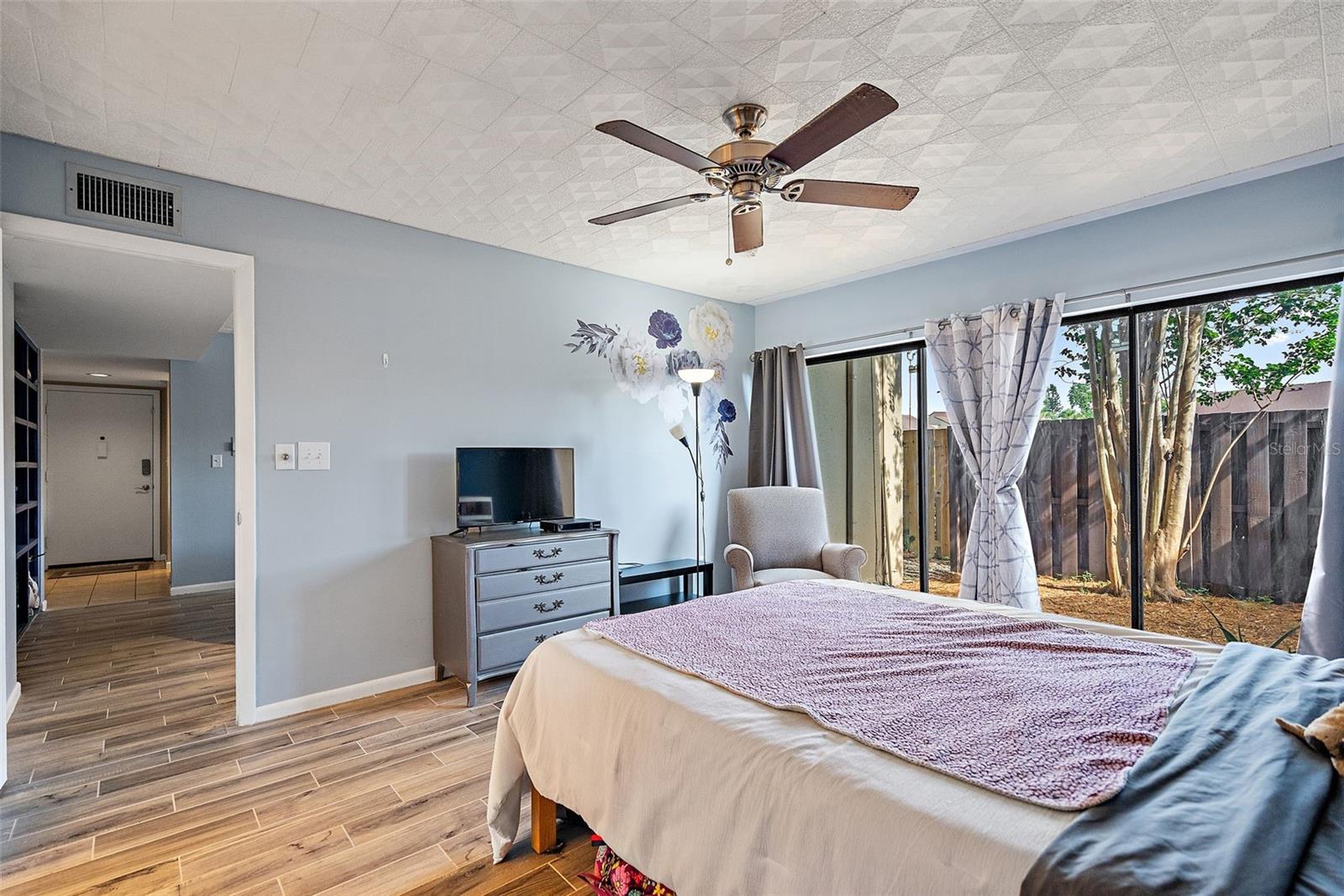 Large bedroom shows off the wood look tile throughout most of the unit