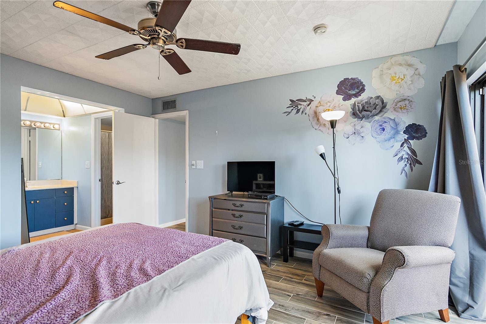 Bright and cozy bedroom (flowers on the wall are decals that can be easily removed)