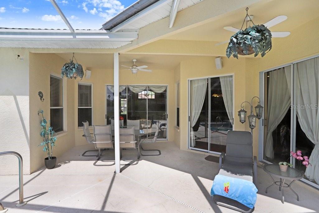 Spacious pool deck with shaded dining and lounge areas
