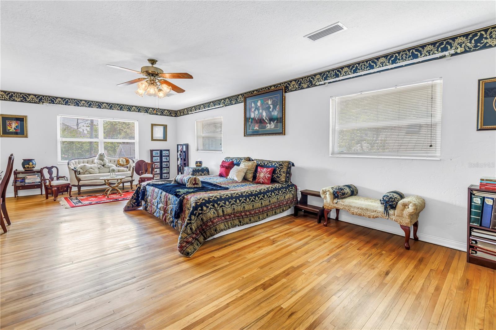 Spacious primary bedroom with high ceilings.
