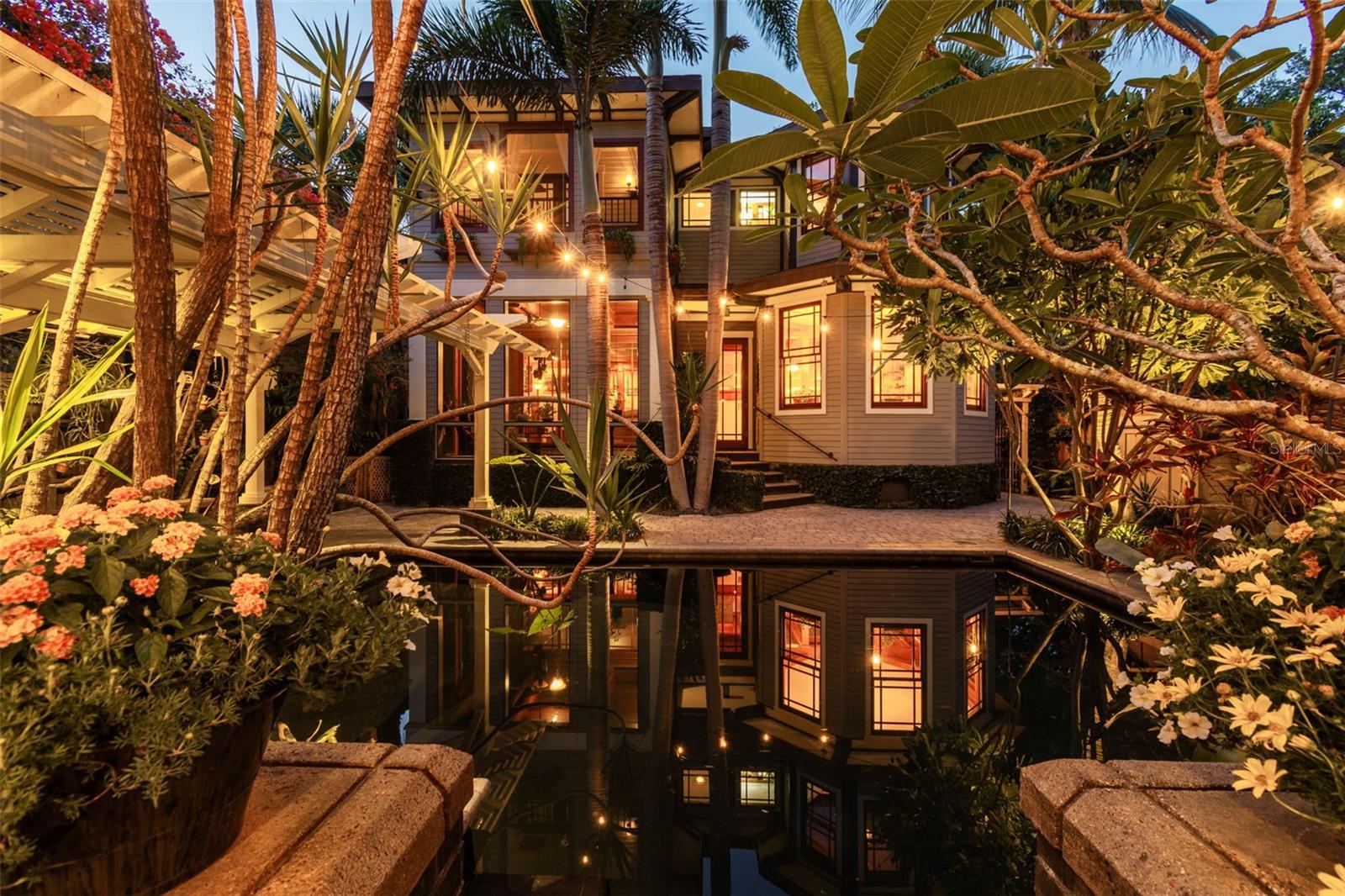 The idyllic dark-bottomed pool captures the reflections of the house and guesthouse
