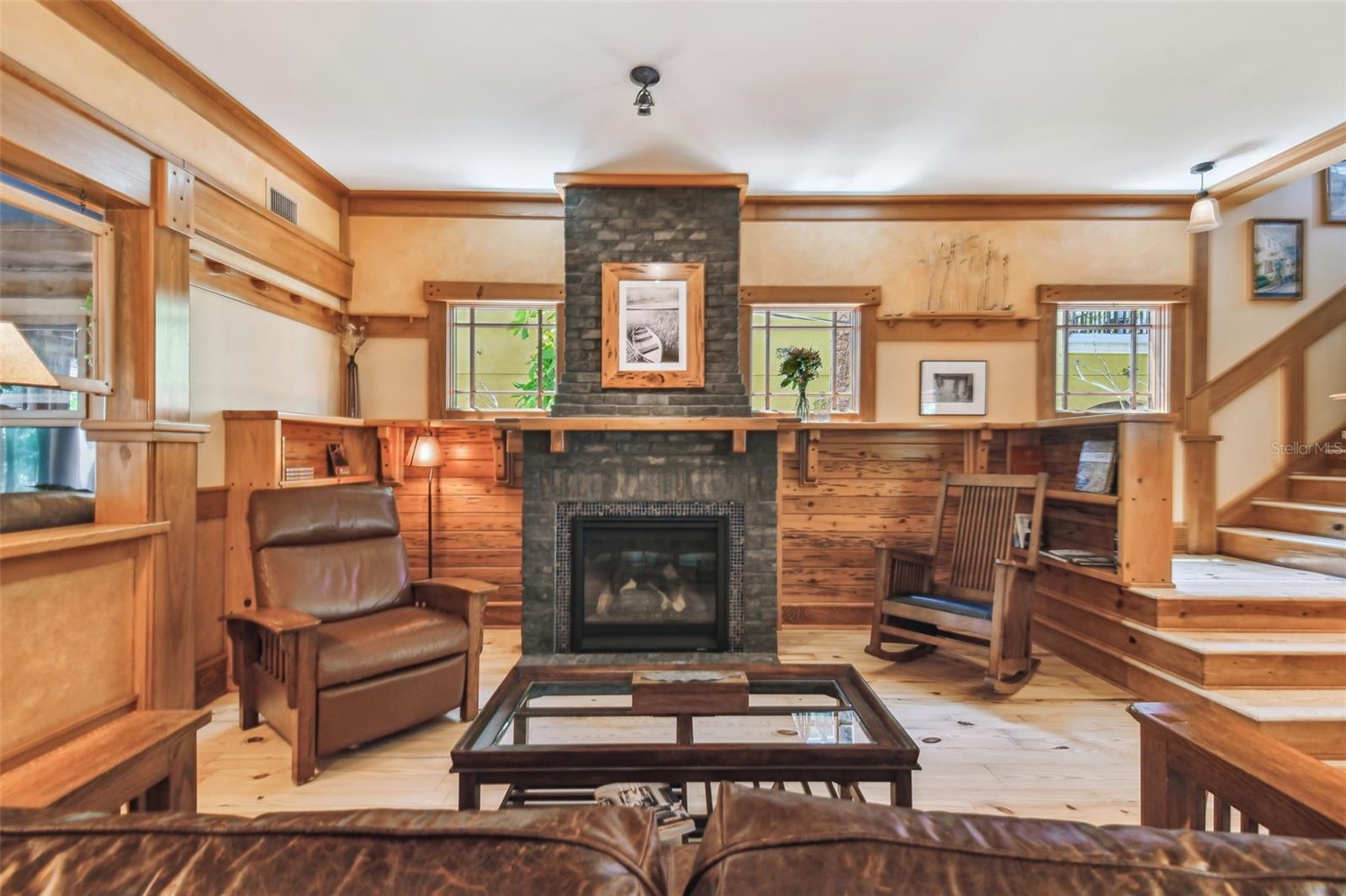 The living room is centered around a hand-laid stone gas fireplace.
