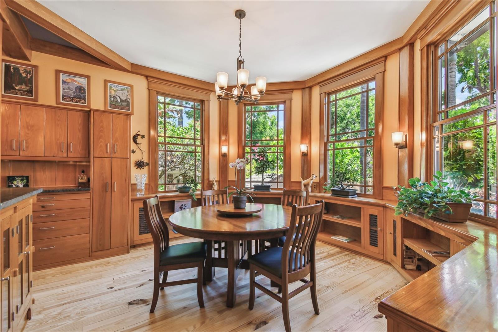 The dining area off the kitchen with walls of windows that draw in sunlight and views of the pool.