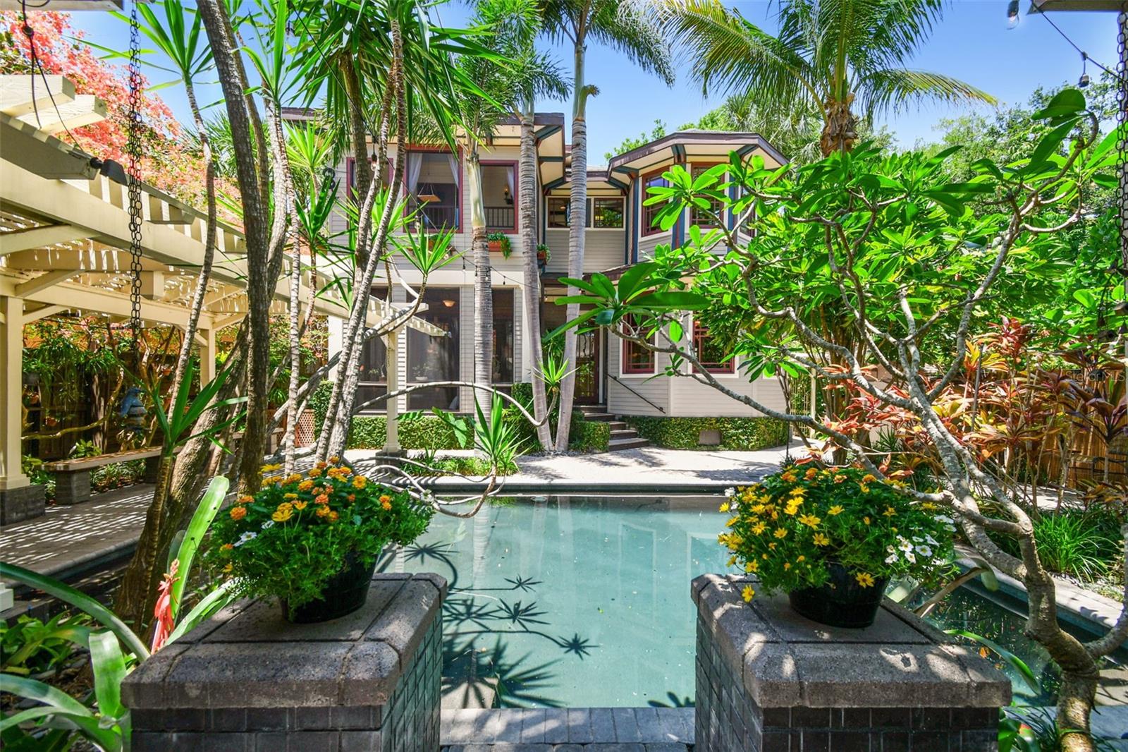 The backyard is a sanctuary where you will find a variety of exotic trees and plants, including unique Bromeliads throughout with Spineless Yuca and Frangipani reaching over the pool