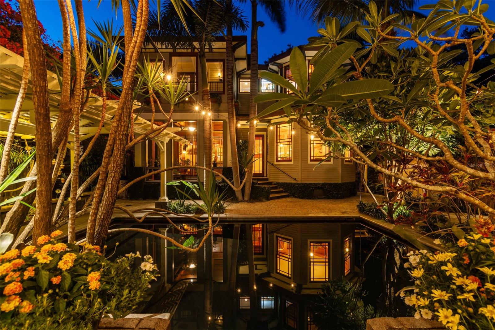 The idyllic dark-bottomed pool captures the reflections of the house and guesthouse