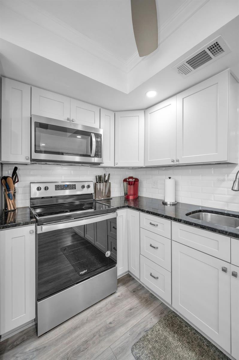 Cooktop stove, built-in microwave, Lazy Susan, soft close drawers, recessed lighting, white shaker cabinets