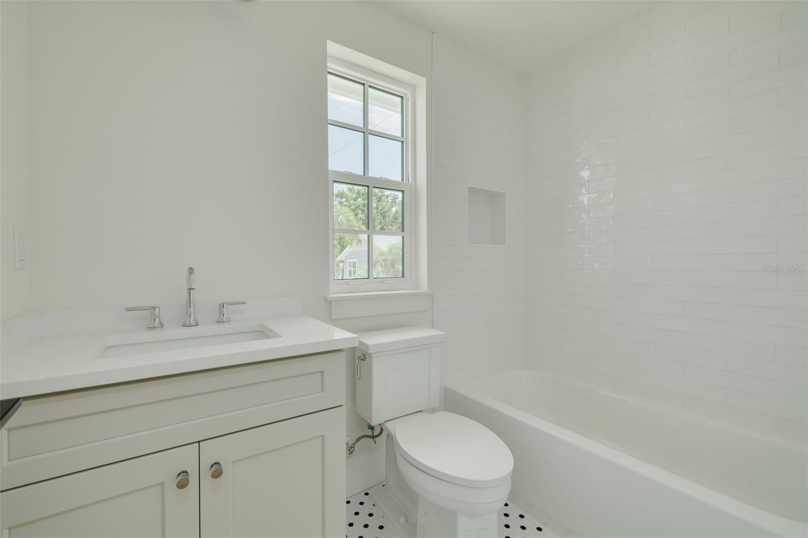 Full bathroom with tub shower in the ADU. This photo is a different model, similar finishes will be provided.
