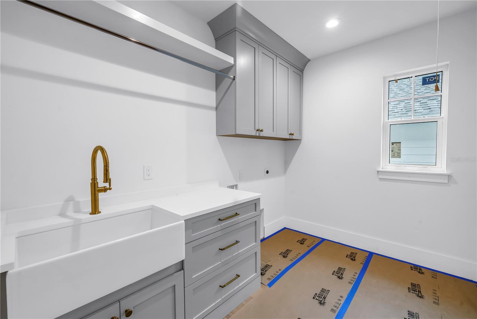 Laundry room on the second level includes utility sink and built-in storage.
