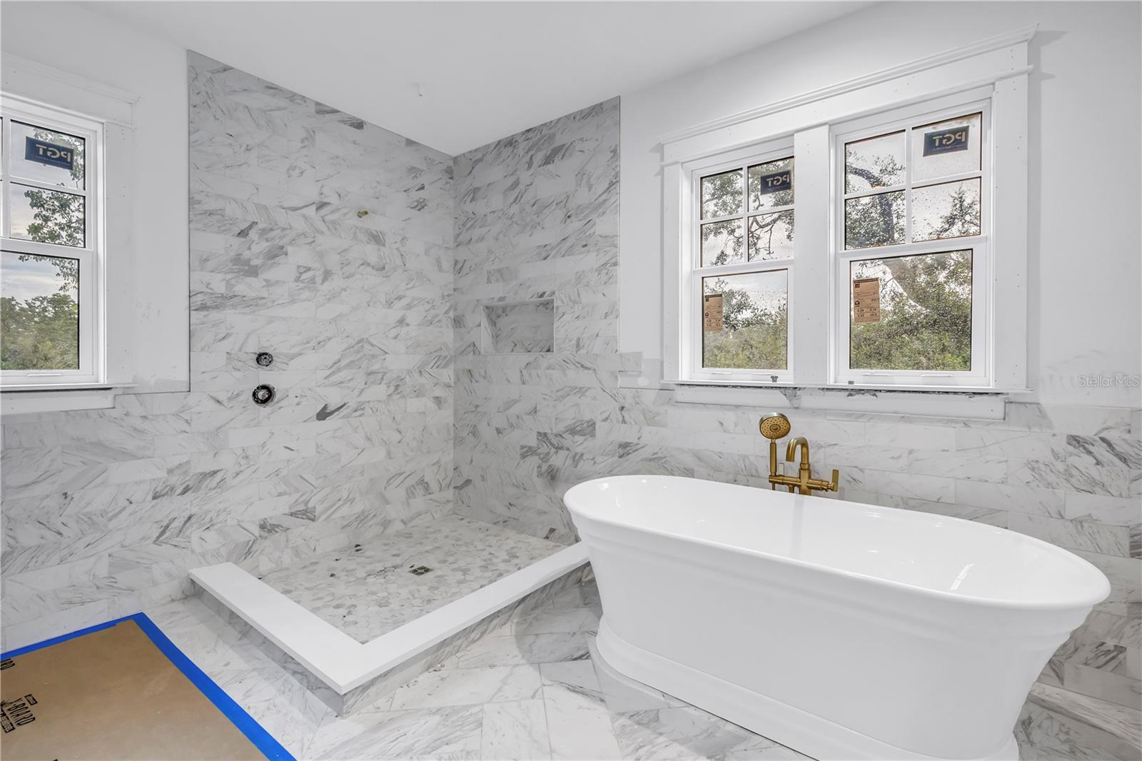 Free standing soaking tub and marble tile throughout