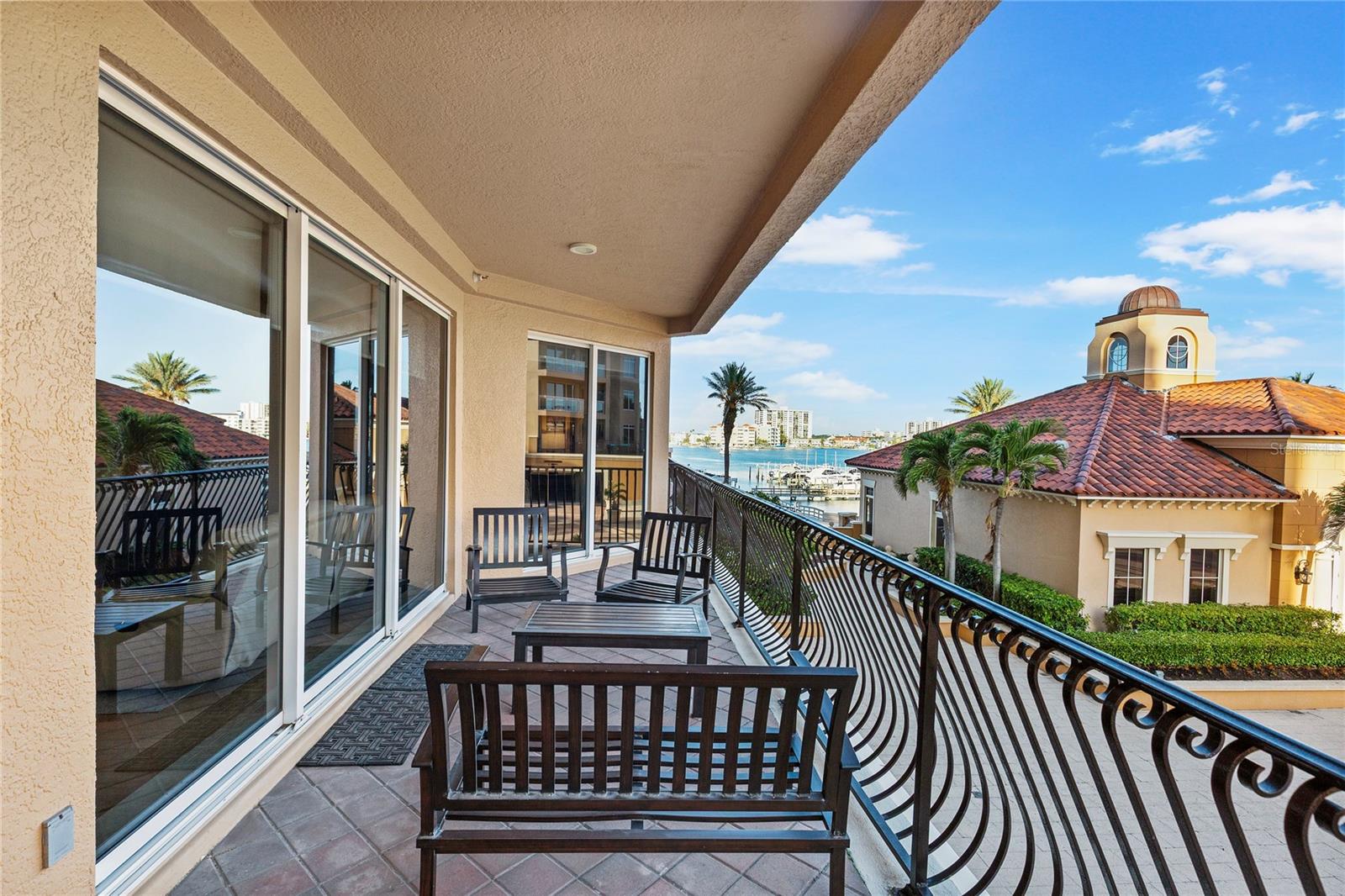 the balcony continues to the front. Access to this part of hte balcony is from the mian living area and the primary bedroom.  With partial views of the water and marina!