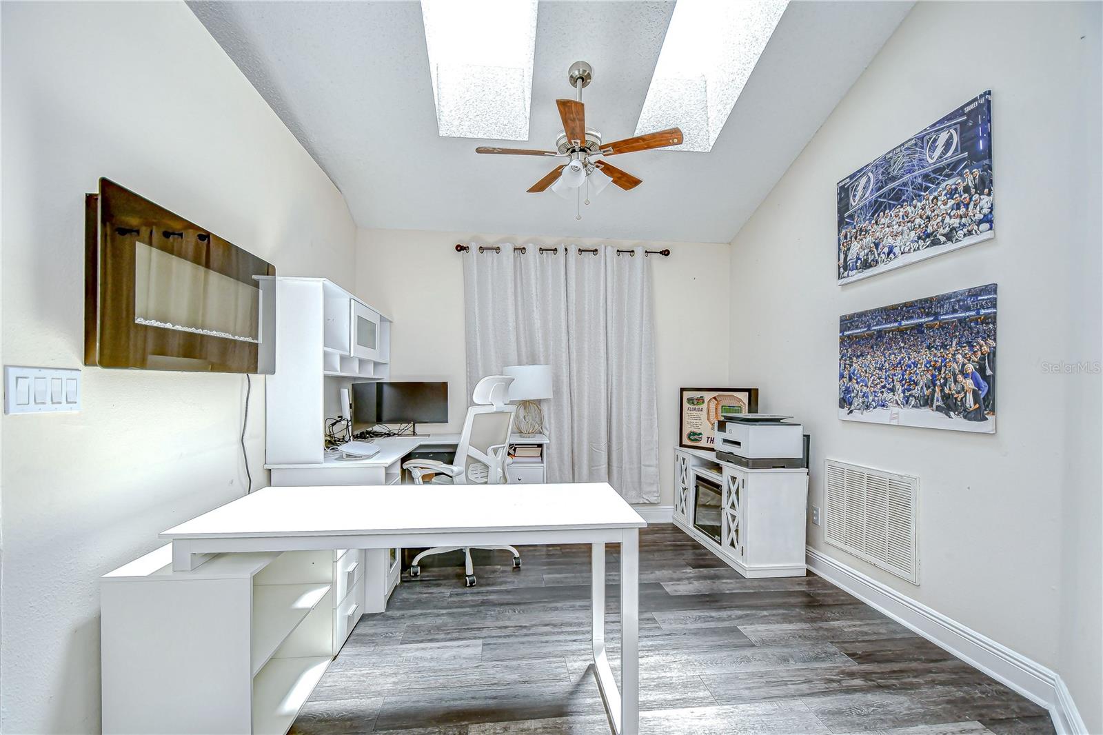 A versatile den with skylights offers flexible living space—currently used as an office!