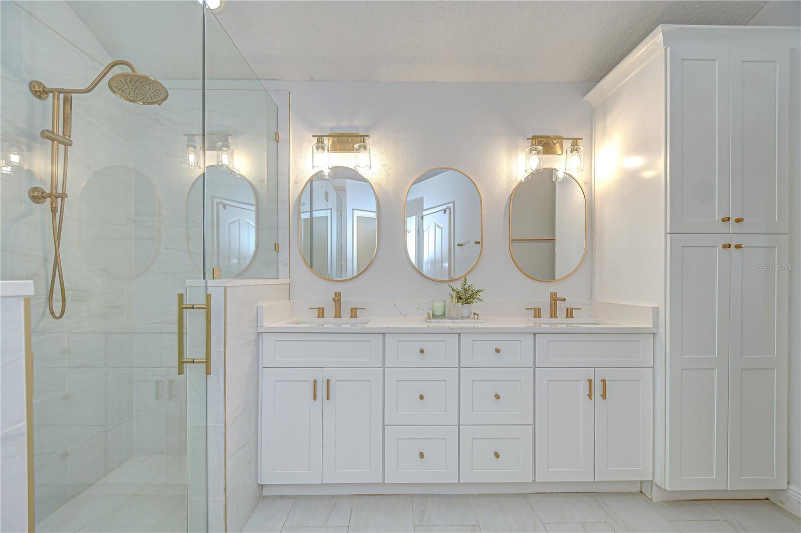Upgraded primary bathroom has dual sinks and triple mirrors!