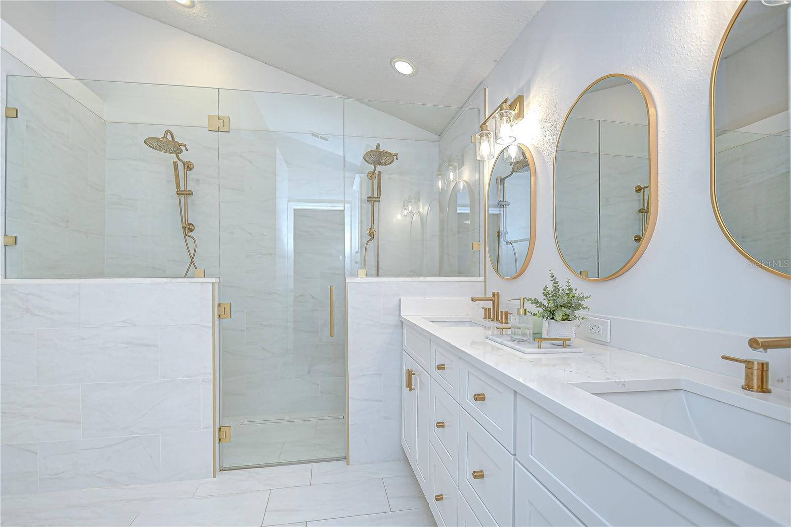 The large walk-in shower with two separate shower heads, a built-in bench, a hidden niche for toiletries, and a touchscreen Moen control system to customize water temperature!