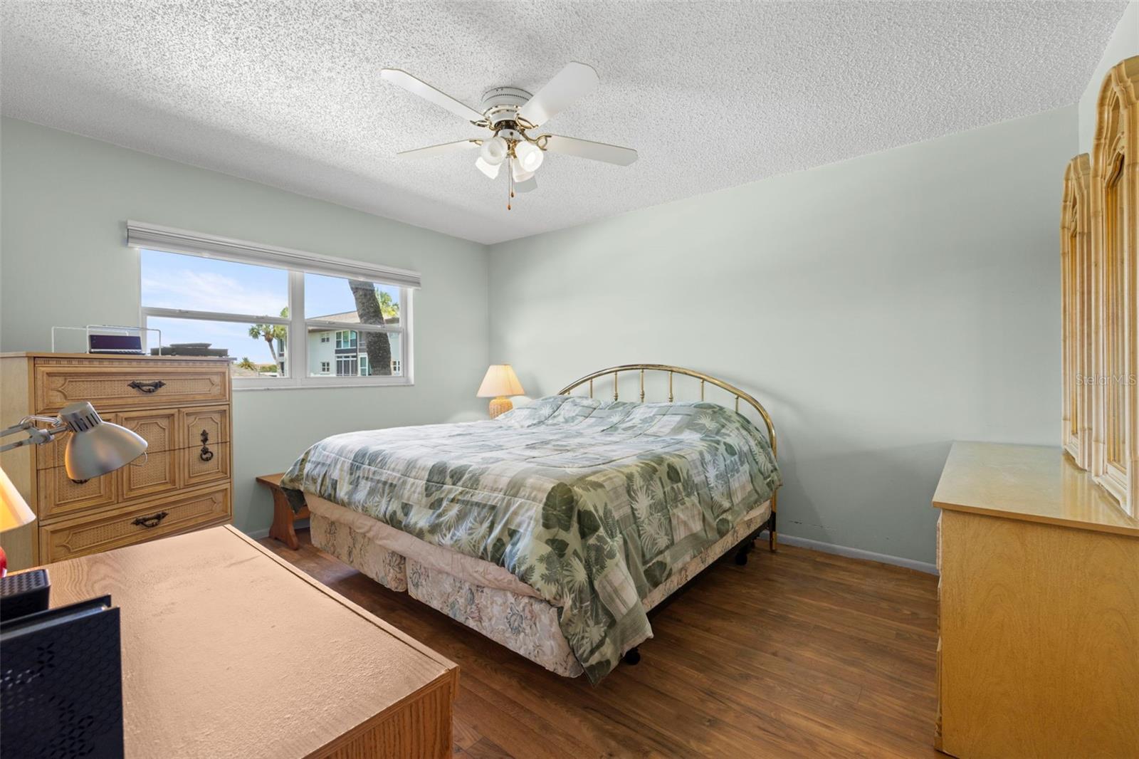 View of primary bedroom is extra large with plenty of room for a king-sized bedroom set, ceiling fan, blinds, glass sliding doors to the lanai.