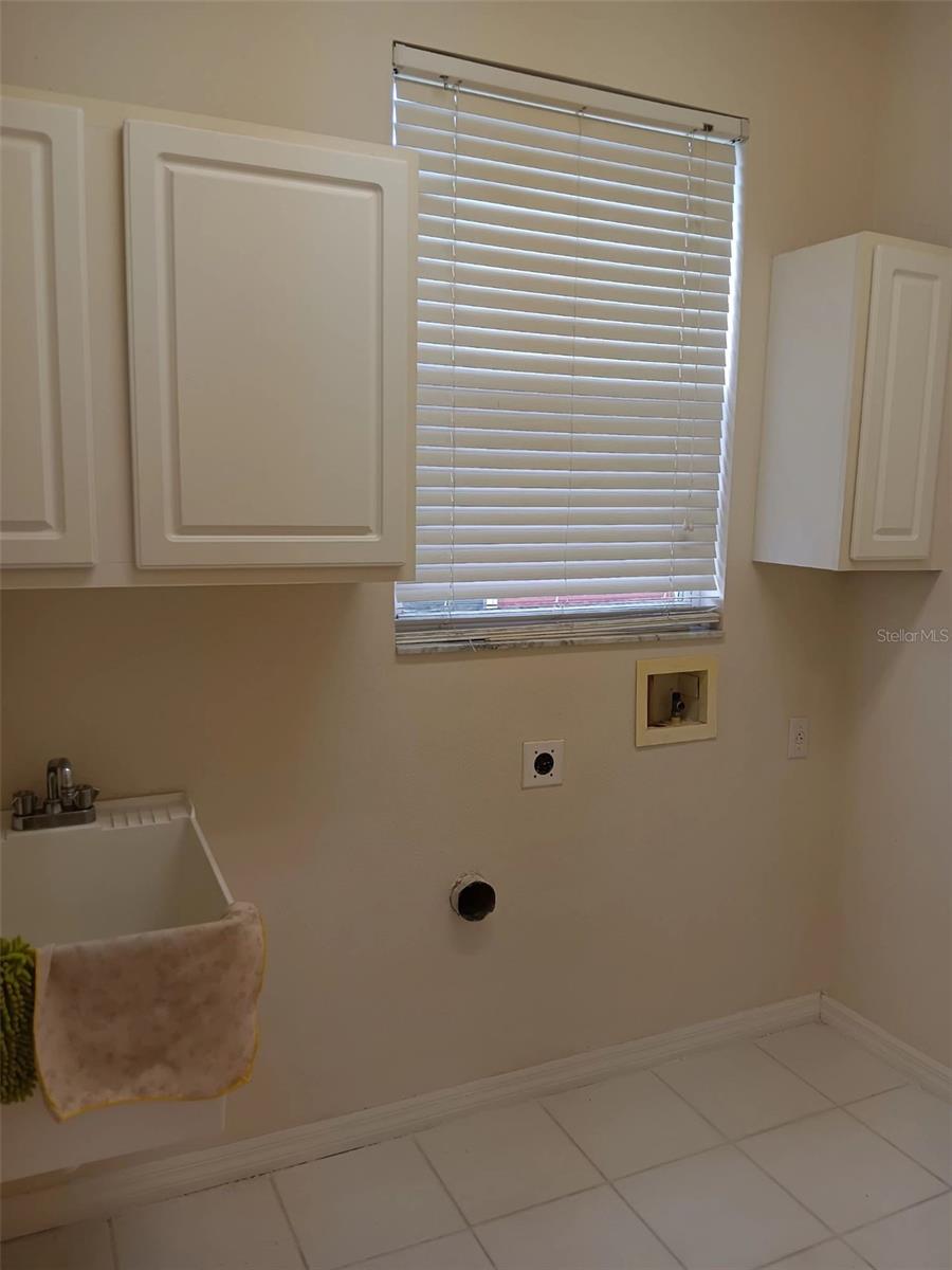 laundry room with cabinets and laundry tub