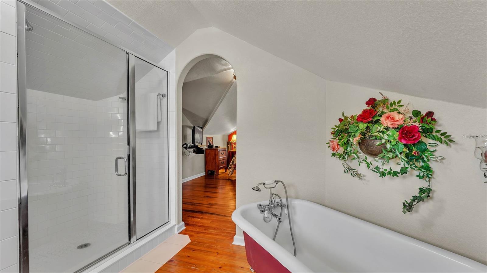 Ensuite bathroom with a classic elegant clawfoot soaking tub, beautifully preserved and perfect for long, relaxing baths.The brand new shower with subway tilework and glass doors is fantastic!