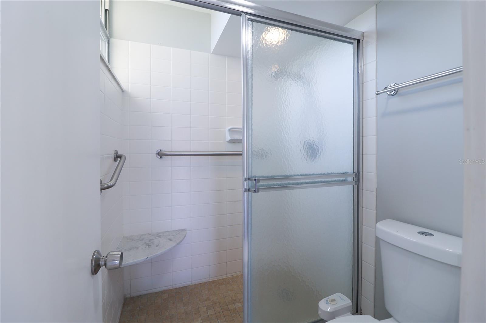 Master shower with shower chair and bars built in