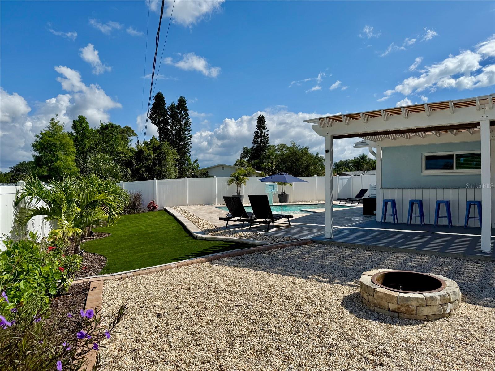 Pebble-surrounded firepit for cozy evenings under the stars.