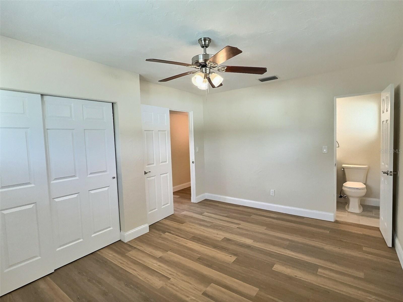 Primary bedroom with built in closet with view into the primary bath.