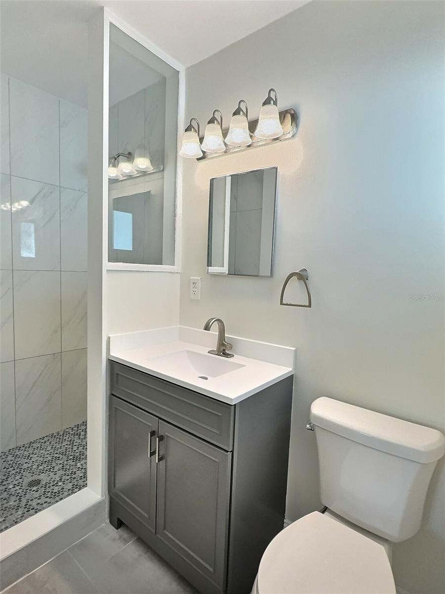 Primary bathroom with vanity and walk in shower.