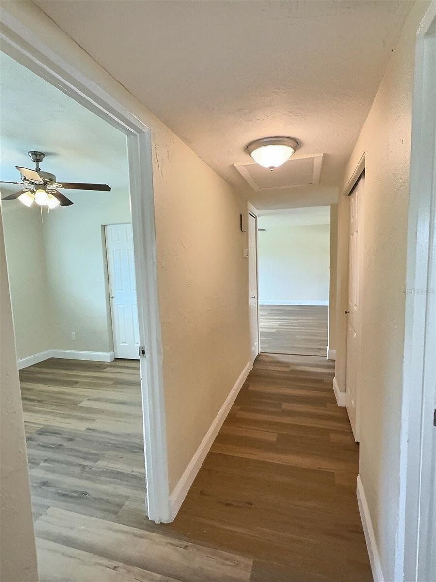Hallway from Bedroom 2, with views into Bedroom 1 and hallyway closet leading back into living room.