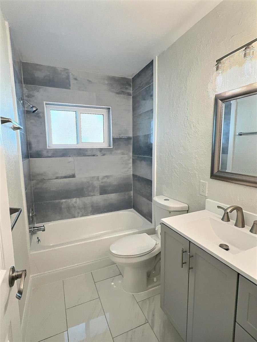 Guest bathroom with tile shower and tub.