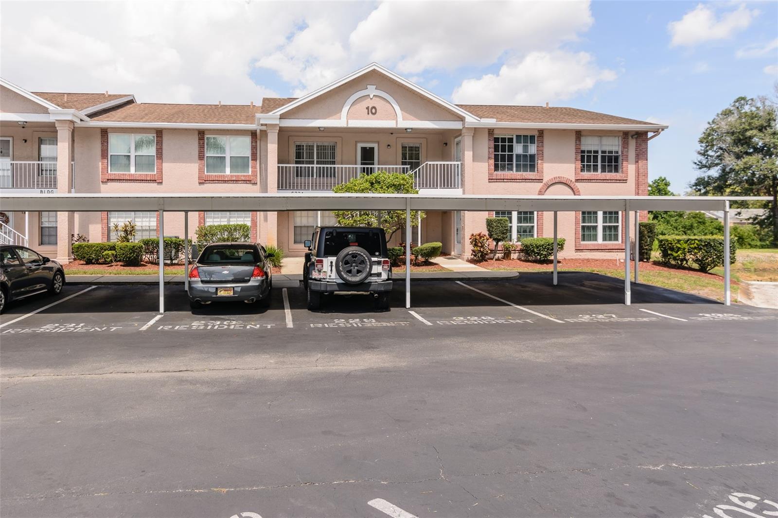 Carport with reserved space in front of unit.  Also guest parking spaces across from building.