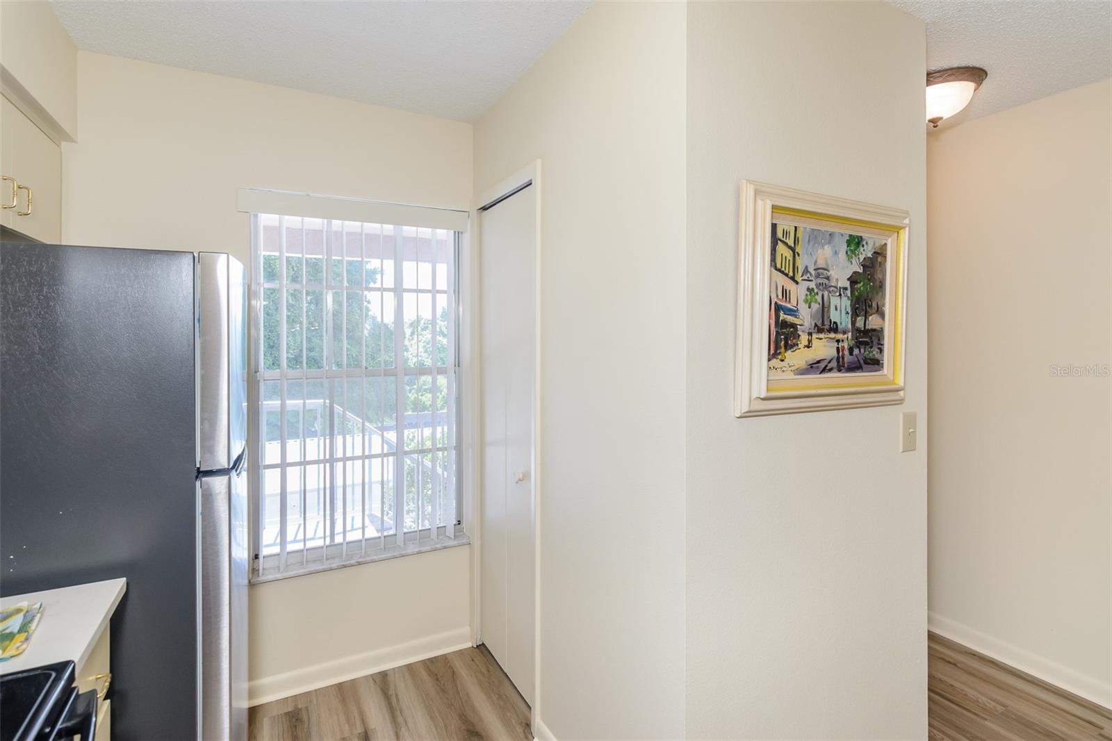 Closet washer and dryer across from refrigerator.
