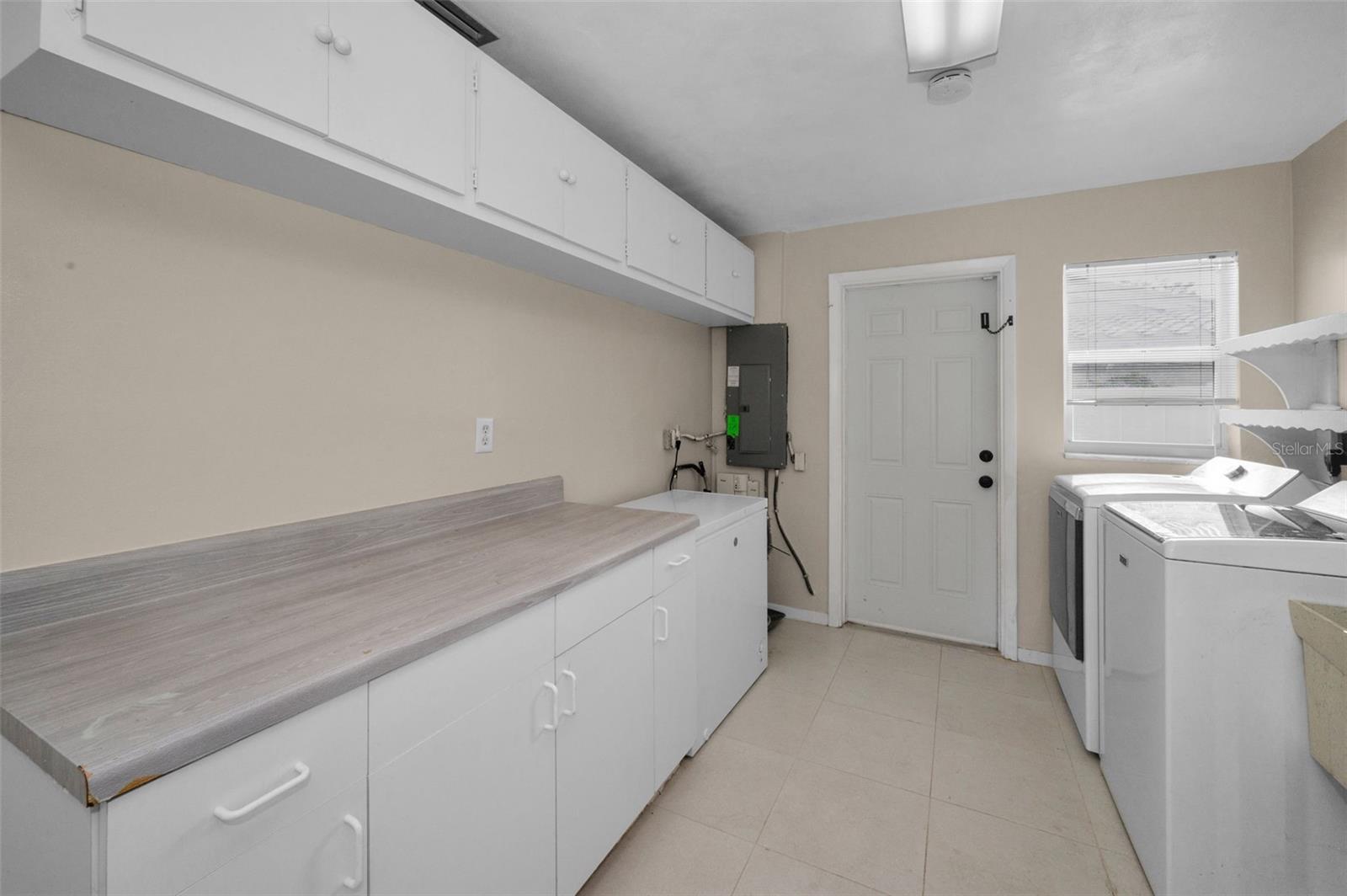 .. Laundry Room 14.7 X 8.11 with Extra Storage Space.. .. Ext Door in Photo Leads to Side Yard. Back Yard Will be to the Right of Door. There Also is access to the Garage on Left and the House Interior on Rigth  Behind Photographer..