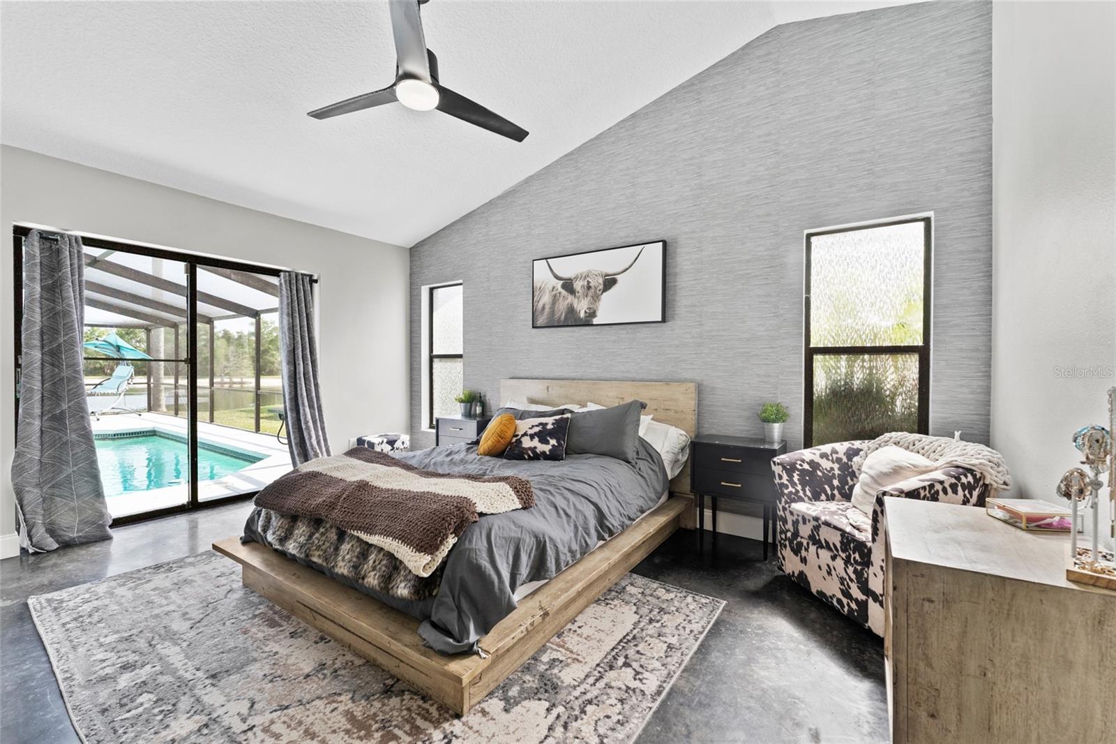 Wake up to views of your private pool! This large primary suite features vaulted ceilings, designer wallpaper, and direct access to the screened lanai—your personal retreat in Tampa living.
