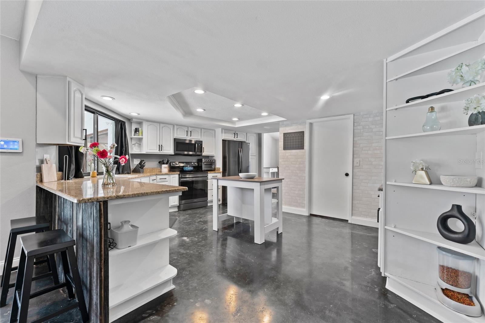 Add personality to your routine with built-in shelves, a breakfast bar, and custom touches that elevate this kitchen space beyond the ordinary. Discover upgraded living in Tampa.