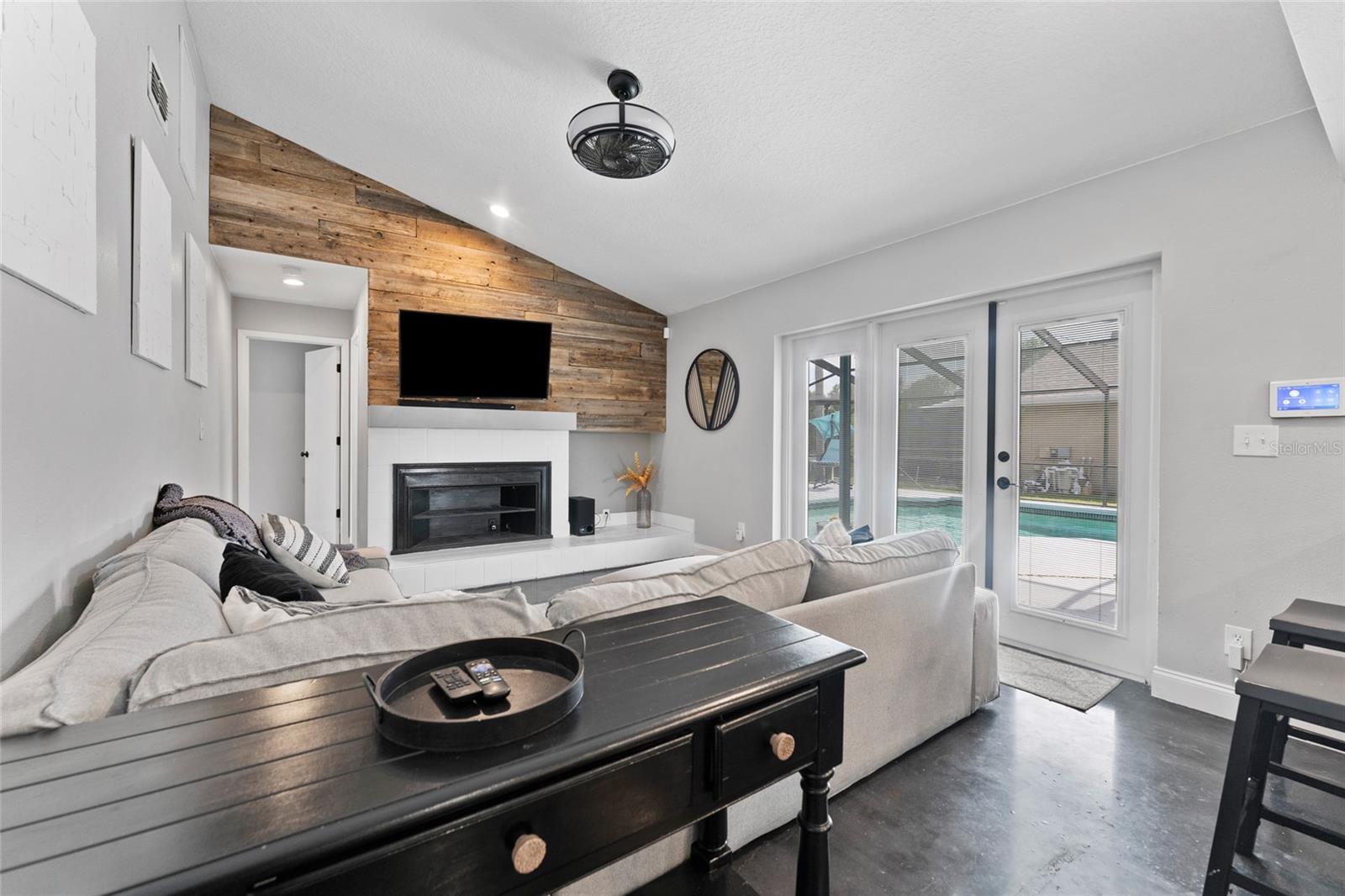 Relax and unwind by the wood-accented fireplace or step through the French doors to your private pool oasis. This living space is designed for comfort and connection.