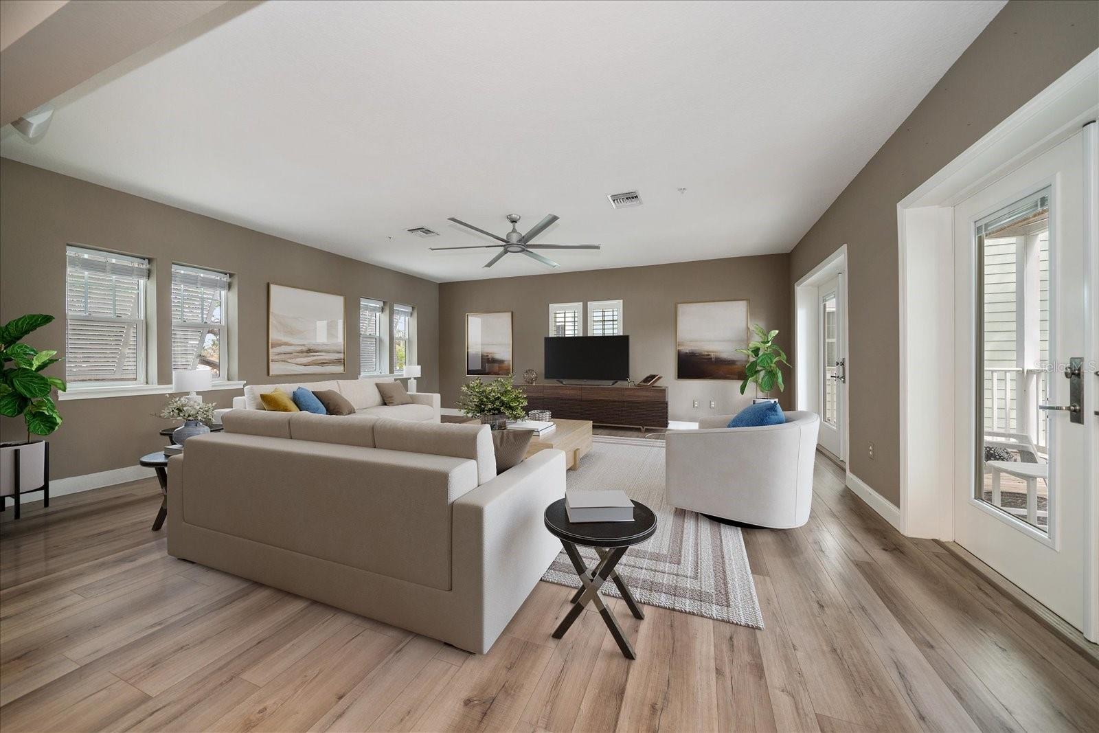 Large great room is bathed by natural light. New impact windows and French doors add peace of mind.