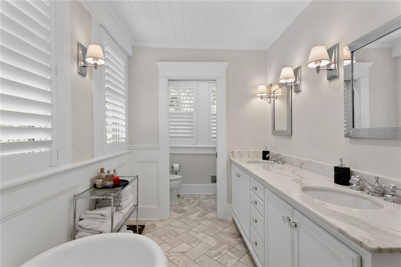 The private primary retreat features a spa-like bathroom with a luxurious soaking tub and elegant marble finishes