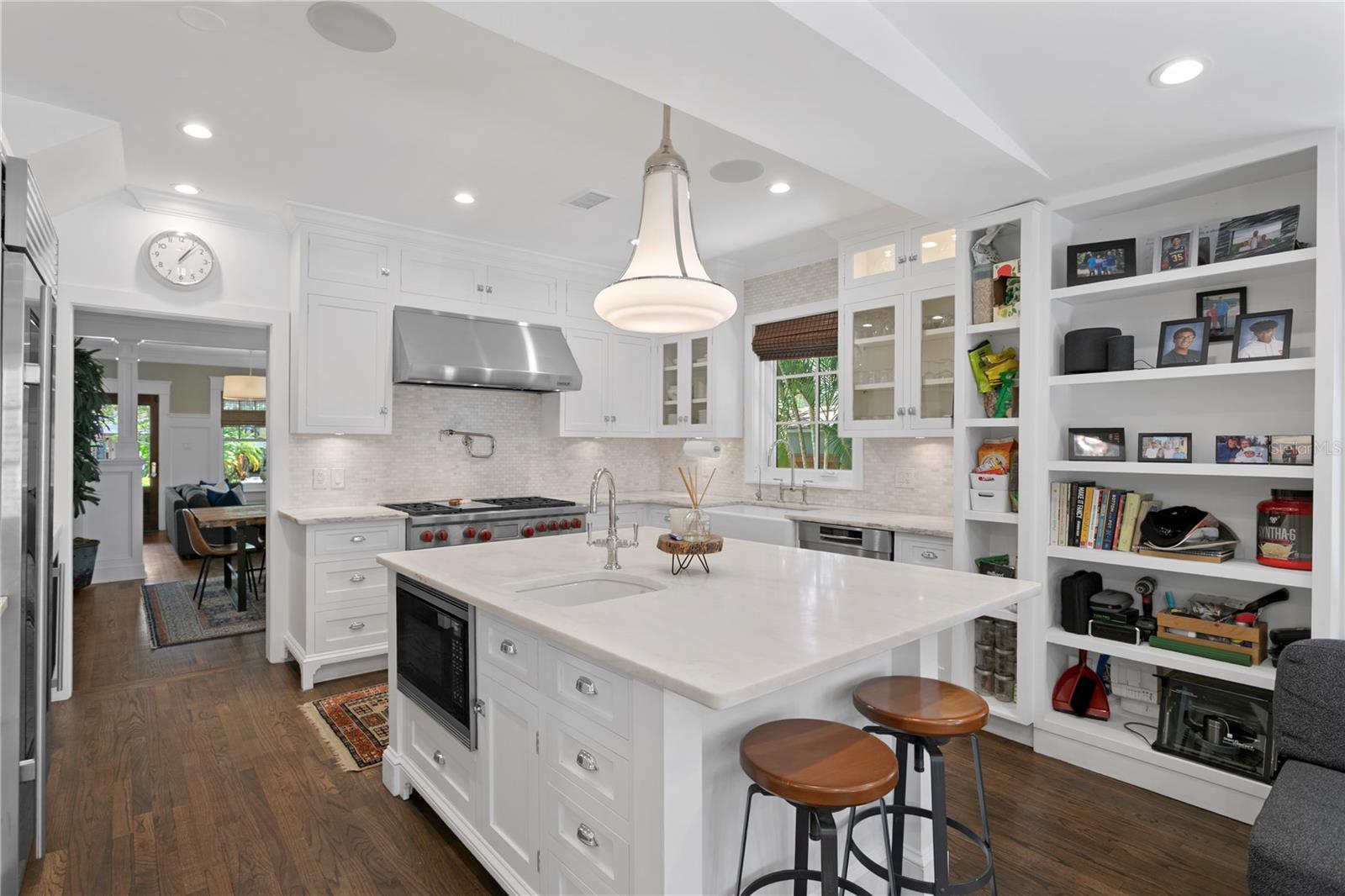 Flooded with natural light, the open concept kitchen features a spacious center island with prep space and a secondary sink, along with top-of-the-line appliances including a Wolf gas range, Sub-Zero refrigerator, and a wine fridge and flows into the family room.