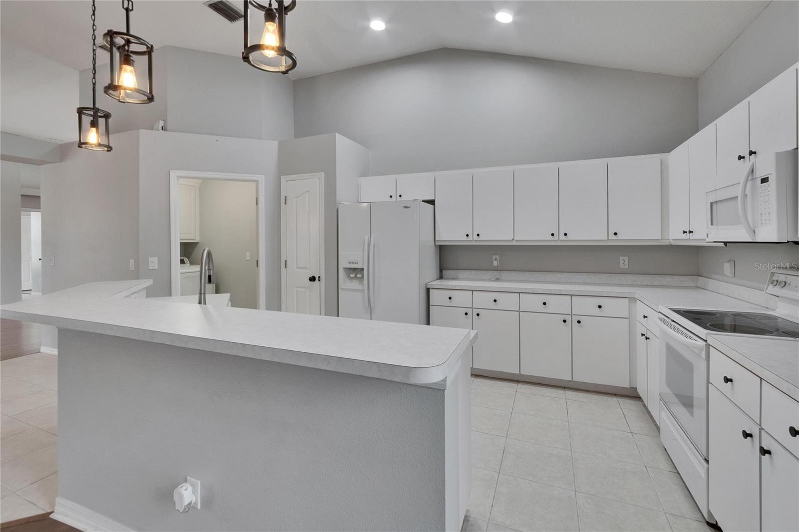 Kitchen and Island. Door to Laundry Room.