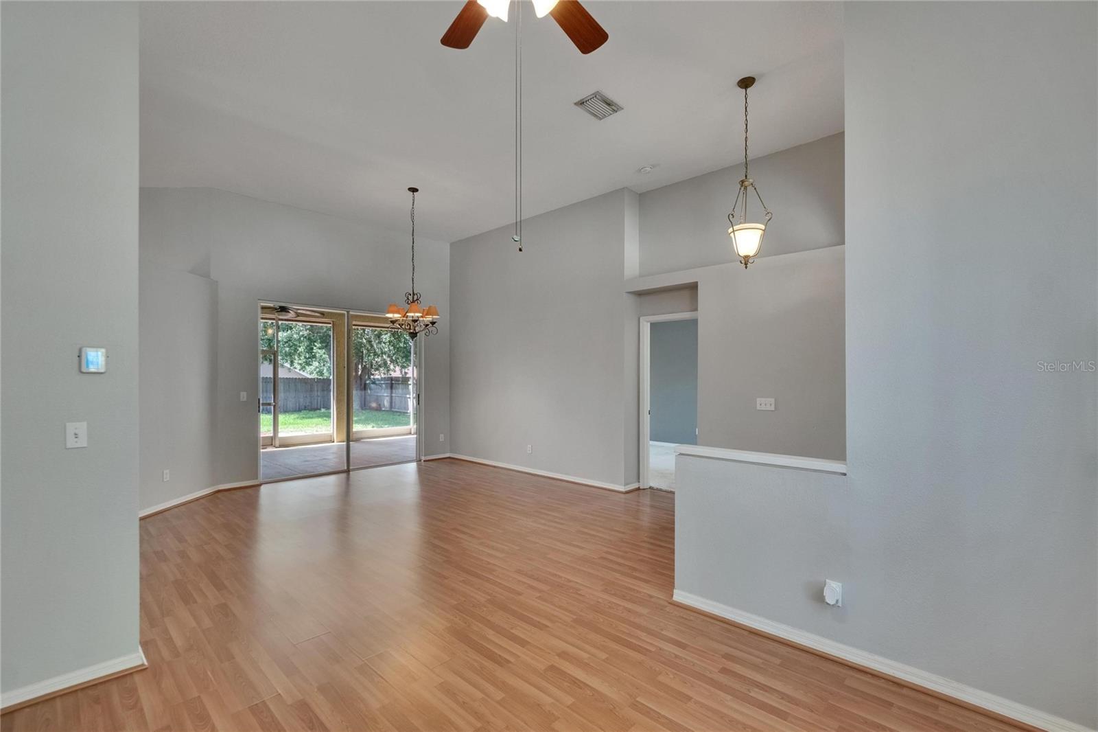 Dining Room Towards Living Room.  Sliders to Lanai. Primary Bedroom door to right